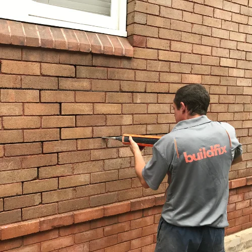 Repointed mortar joints on brick wall after remedial tie installation