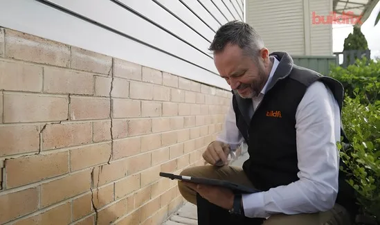Buildfix structural engineer assessing foundation subsidence with laser level equipment