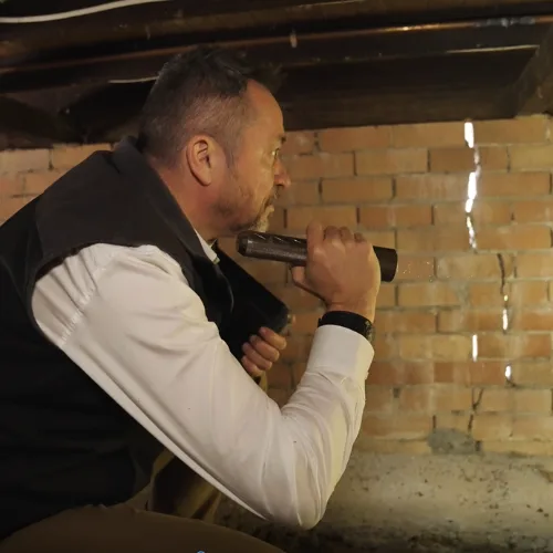 Buildfix structural engineer assessing floor levels and stump condition with laser equipment