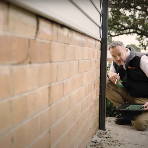 Buildfix structural engineer assessing foundation movement with laser level equipment