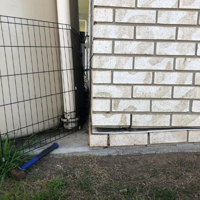 Corner of brick home sinking away from ground level