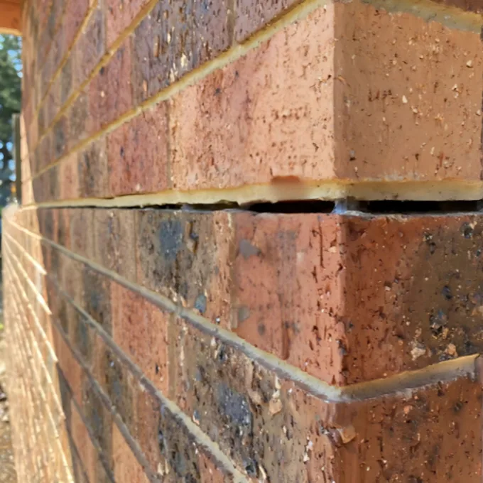 Horizontal crack running along mortar course in brick wall from foundation movement